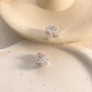 Close-up of square zircon stud earrings with silver plating and prong-set crystals