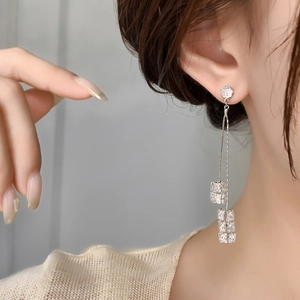 Gros plan de boucles d'oreilles pendantes en argent avec zircons brillants sur un mannequin