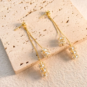 Détail de boucles d'oreilles pendantes à pompons et boules de cristal brillant