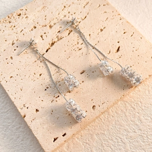 Vue détaillée de boucles d'oreilles longues argentées avec cristaux et chaînes