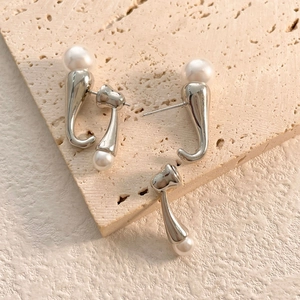 Detailed view of silver minimalist curved drop earrings with smooth white pearls