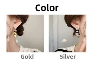 Detail view of layered shell-shaped earrings in gold and silver with cubic zirconia