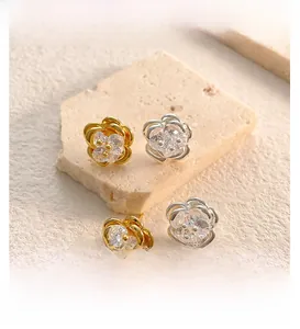 Close-up of 18K gold plated camellia earrings with sparkling cubic zirconia inlay