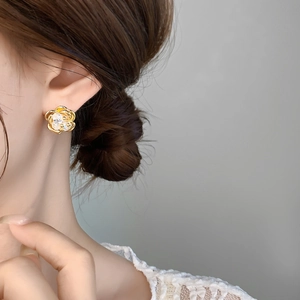 Close-up of elegant 18K gold plated flower earring with zircon on a model's ear