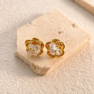 Detailed close-up of 18K gold plated camellia flower earrings with zircon centers