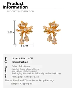 Detail view of gold-plated flower stud earrings with pearls and zircon pendants