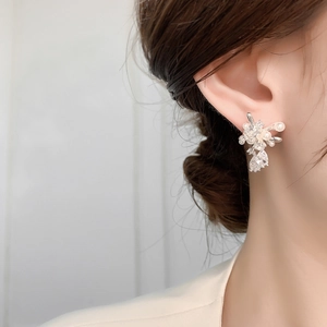 Close-up of elegant firework stud earrings with lustrous pearls and sparkling zircons