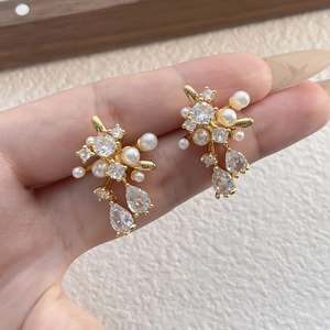 Sparkling firework stud earrings with white pearls and clear zircons in gold finish