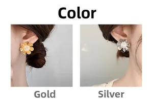 Close-up of gold and silver flower earrings with zircon centers on model ear