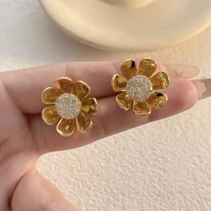 Elegant gold flower stud earrings with 3D petals shown in a high-quality hand display