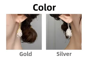 Macro detail of fireworks design tassel earrings in gold and silver crystal finish