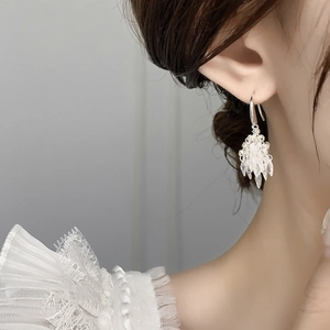 Detail of ice cluster dangle earring featuring translucent crystal geometric pendants