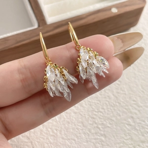 Macro shot of gold firework drop earrings featuring cluster-set marquise cubic zirconia