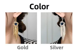 Détail de boucles d'oreilles à pompons avec cerceaux torsadés et cristaux bleus, or et argent