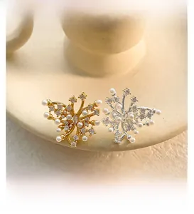Macro detail of butterfly flower earrings with white pearls and sparkling crystals