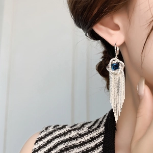 Détail de boucles d'oreilles pampilles en argent avec zircon bleu foncé et fines chaînes