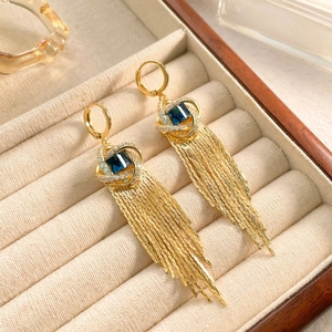 Détails des boucles d'oreilles dorées à pampilles avec pierre bleue et franges zircon