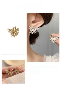 Macro detail of gold and silver butterfly earrings with pearls and crystal accents