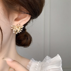 Elegant gold flower stud earrings featuring white pearls and sparkling cubic zirconia stones