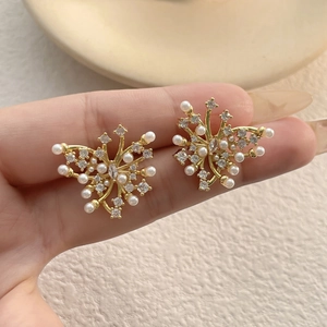 Elegant gold butterfly earrings with white pearls and sparkling cubic zirconia crystals