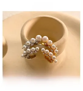Dettaglio di orecchini a forma di C in perle e zirconi stile vintage francese chic