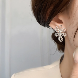 Elegant silver bow stud earrings with twisted metal texture and floral hollow design