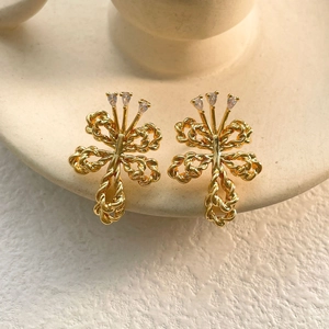 Detail of gold-plated twisted bow earrings featuring sparkling cubic zirconia stones