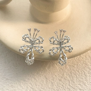 Detailed view of silver bow-shaped earrings with twisted wire and pear-cut cubic zirconia