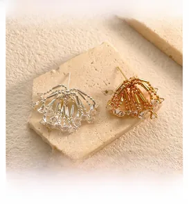 Macro shot of silver and gold fan tassel earrings with sparkling zircon crystals