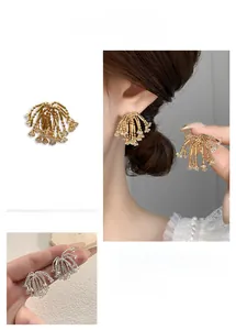 Detail of sparkling zircon tassel earrings in gold and silver finish on model