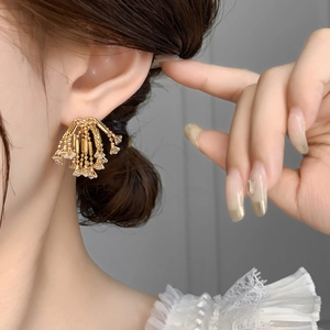 Detail shot of vintage golden tassel earrings with sparkling crystals on female model
