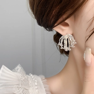 Macro shot of sparkling zircon firework tassel earrings on model with white lace