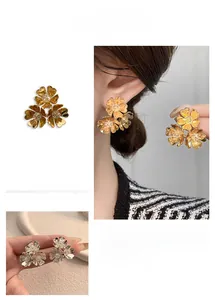 Macro detail of gold and silver floral C-shaped earrings with sparkling cubic zirconia