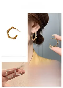 Nahaufnahme der C-förmigen Ohrringe mit Zirkonia-Inlays in Gold und Silber-Ausführung