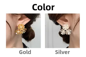 Detail view of gold and silver vintage floral C-shaped earrings with rhinestone centers