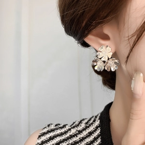 Close-up of elegant triple flower silver stud earrings on a model showing daily wear style
