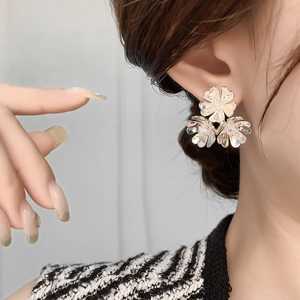 Elegant vintage silver flower C-shape stud earrings worn by a model for a stylish look