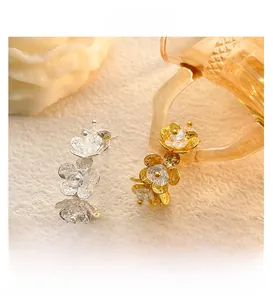 Detailed macro shot of triple flower petal earrings with zircon and hammered metal texture