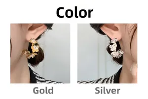 Detail view of C-shaped floral cluster earrings in gold and silver finish with rhinestones