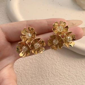 Elegant gold C-shaped earrings with triple flower cluster and sparkling zircon centers