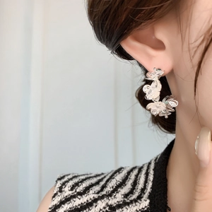 Elegant silver layered flower earrings with shimmering diamond-like finish on model