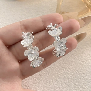 Elegant silver flower drop earrings with four crystal-encrusted petals in a vertical layout