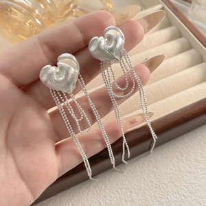 Silver heart earrings with beaded chain tassels and brushed metal texture finish