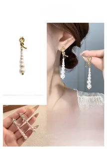 Détail de boucles d'oreilles nœud asymétrique avec perles dégradées portées