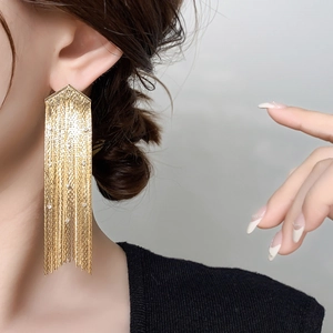 Détails des boucles d'oreilles longues à pampilles dorées avec texture en maille et reflets