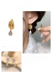 Detail of hollow drop earrings with pear-cut zircon and vintage bamboo texture