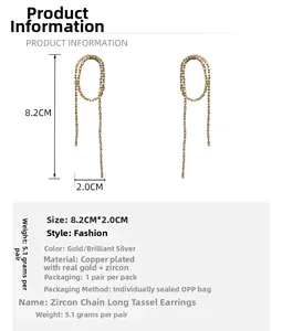 Close-up of sparkling zircon tassel earrings in gold finish with size measurements