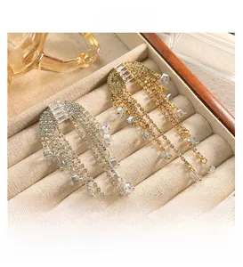 Macro detail of luxury zircon tassel earrings in gold and silver finish on velvet