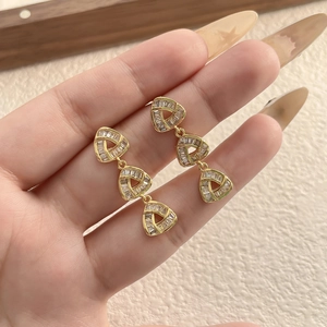 Three-tier gold triangle drop earrings with baguette-cut cubic zirconia inlays