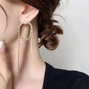 Detail of long tassel earrings with rectangular crystals on 18K gold plated base